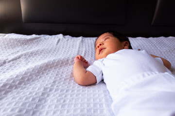 beautiful newborn hispanic baby on a white sheet, calm and relaxed