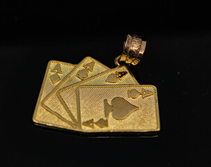 dije de cartas en oro amarillo con fondo negro 