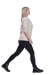 Fototapeta premium smiling woman in a white jacket striding confidently forward.