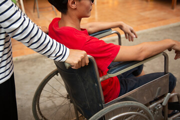 Obraz premium Women pushing a wheelchair, men to relax inside the home