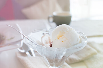 Ice cream ball in transparent plate cup bowl in a cafe abckground light