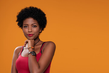 Attractive beautiful afro woman posing on orange studio background,