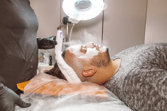 man receiving a facial in a beauty salon