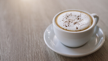 cup of cappuccino on wooden table.