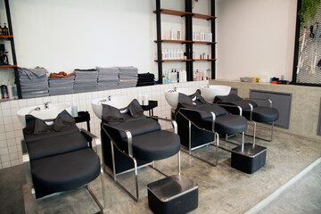 Salon interior That has a black leather chair in front of a mirror in the salon..