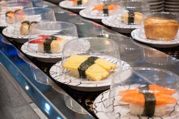 Sushi on conveyor belt in a Thailand restaurant. Shushi Go Round is a famous form of fast food in...