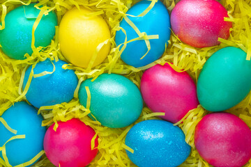 Fototapeta na wymiar Easter background of colorful eggs on a festive yellow background. Top view Selective focus. Close-up. Copy space