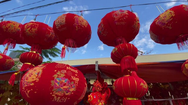 Slowmotion shot of colorful red and golden Chinese lanterns sold on an Asian street market prior to the Tet holiday or Lunar new year in Asia. TET concept. Travel to Asia. Letterings on lanterns and