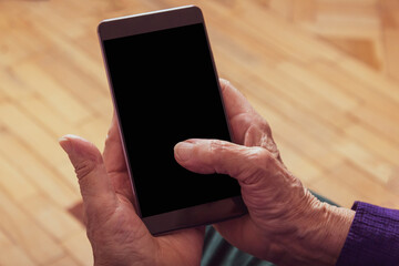 Very old woman holding cell phone. Close-up.