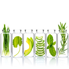Homemade skin care with natural ingredients wheat grass ,avocado ,aloe vera ,mint leave ,centella asiatica and rosemary in glass bottles isolate on white background.
