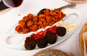 Spanish cuisine. Hot snack with morcilla, chopped chorizo, spicy picadillo and baked aromatic...