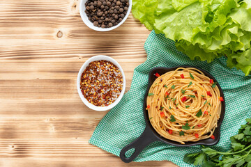 Italian pasta in a frying pan on a wooden background. Top view.