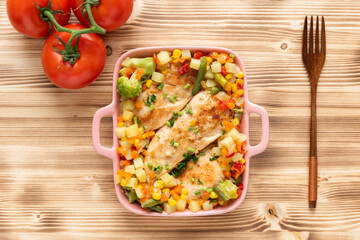Fried chicken with vegetables corn and broccoli on a wooden background. Top view.