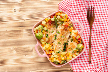 Fried chicken with vegetables corn and broccoli on a wooden background. Top view.