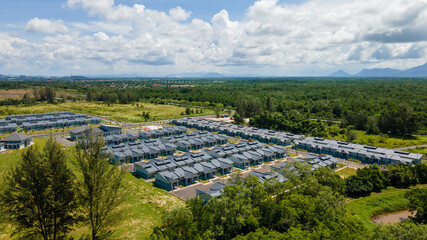 Aerial view of residential housing surrounded by green forest area 