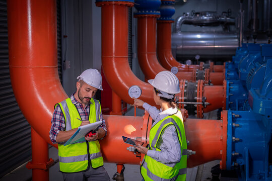 Industry engineer under checking the industry cooling tower air conditioner is water cooling tower air chiller HVAC of large industrial building to control air system.