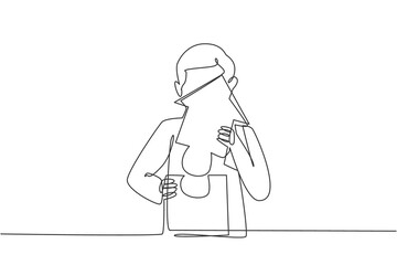 Continuous one line drawing of young handsome male worker arrange puzzle piece into building. Success business manager minimalist concept. Trendy single line draw design vector graphic illustration