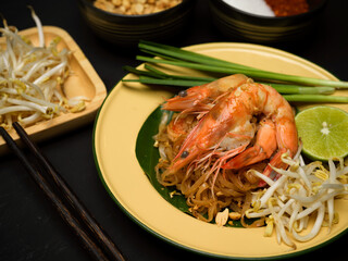 Cropped shot of Pad Thai, stir fired Thai noodles with shrimps serving with lime, beansprouts and...
