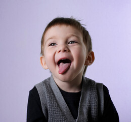 Two year old boy smiling with tongue sticking out
