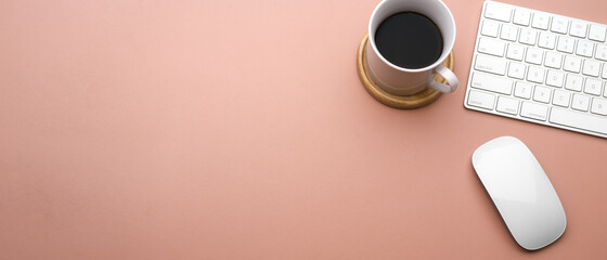 Pink creative flat lay workspace with coffee cup, keyboard, mouse and copy space