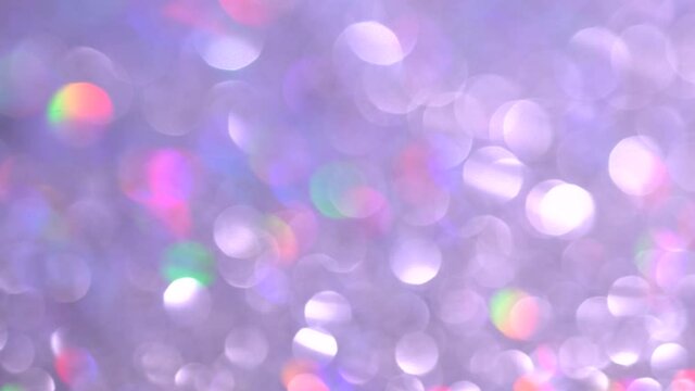 Festive blurred holographic iridescent spectrum colors lights. Holiday background of abstract glitter bokeh with multiple colors. Blue pink purple neon pastel gradient of diamonds.