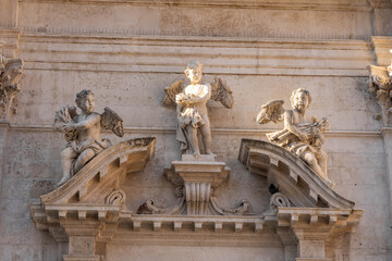 Marble statue of angles on porch in Dubrovnik old town in Croatia morning sunlight