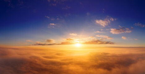 view from an airplane on a beautiful saturated sunrise above the clouds