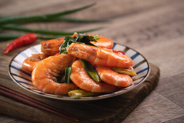 Delicious pan-fried shrimp on dark wooden table background.