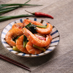 Delicious pan-fried shrimp on dark wooden table background.