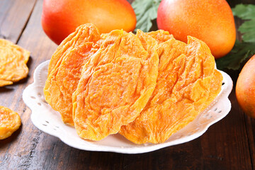 Dried Taiwan mango Dried Taiwan mango white plate on old wooden background.(mango candied)
