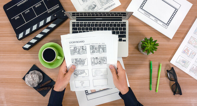 Top view of scriptwriter's workplace - laptop and storyboard with cup of coffee