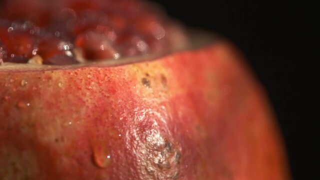 Pomegranate fruit. Slow motion shot. Fresh and ripe Pomegranates rotating over black Background. Organic Bio fruits close-up. Diet, dieting concept. Vegan foo