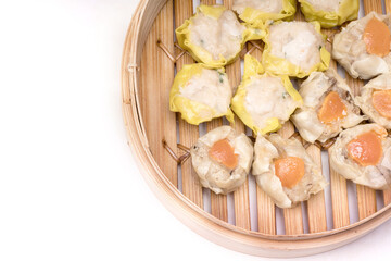 Pork and Crab Dumplings Ready to serve in an oriental woven bamboo basket on a white background