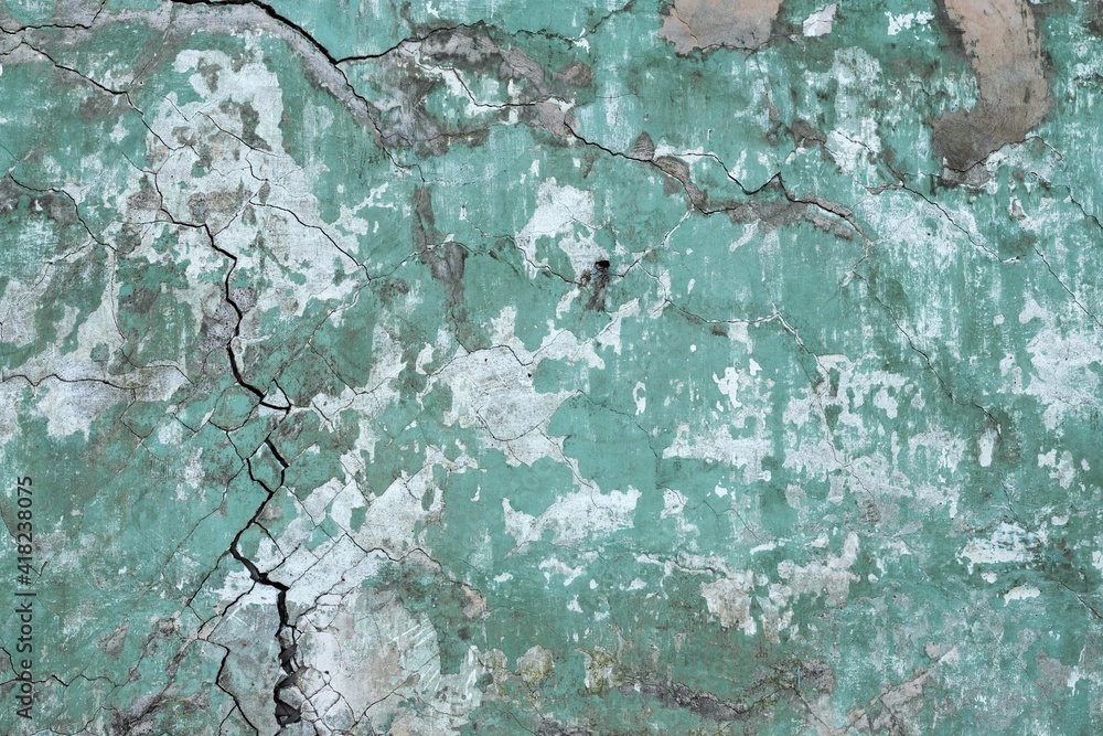 Wall mural background texture of a wall with old cracked green plaster.