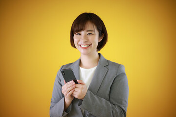 Fototapeta premium スマートフォンを持つ女性社員