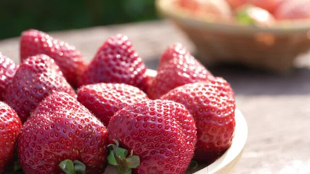 Fresh strawberries with leaves on bamboo basket, Red and White strawberry in Bamboo basket on wooden table.