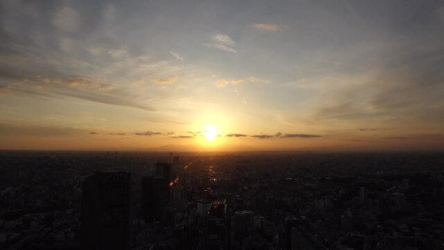 TOKYO, JAPAN : Aerial sunrise CITYSCAPE of TOKYO and MOUNT FUJI. View of rising sun and buildings around Shibuya. Japanese urban city life and nature concept. Long time lapse video, night to morning.