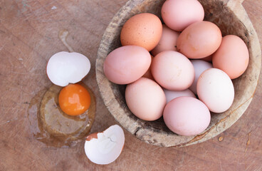 a broken egg and intact eggs, yolk and egg whites on wooden background. Copy space for your text. selective focus