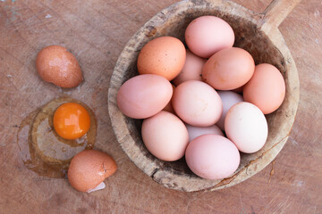 Eggs in wooden bowl with wooden background for healthy and organic food. Copy space for your text.