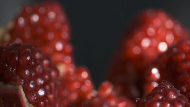 Pomegranate fruit. Slow motion shot. Fresh and ripe Pomegranates rotating over black Background. Organic Bio fruits close-up. Diet, dieting concept. Vegan foo