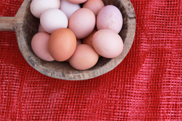 eggs in the wooden bowl and red nature background. Copy space for your text.
