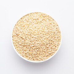 Close up of Organic split polished white urad dal (Vigna mungo) on a ceramic white bowl. Top view 