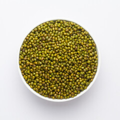 Close up of Organic green Gram (Vigna radiata) or whole green moong dal on a ceramic white bowl. Top view 