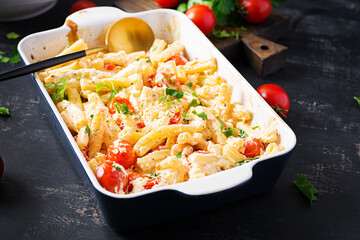 Fetapasta. Trending viral Feta bake pasta recipe made of cherry tomatoes, feta cheese, garlic and herbs in a casserole dish.