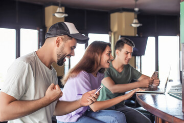 Happy young people after winning of their sports bet in pub