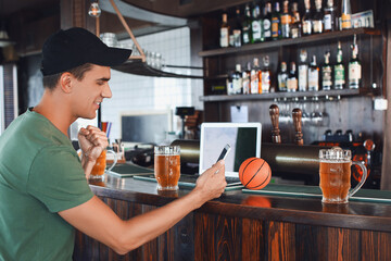 Young man placing sports bet in pub