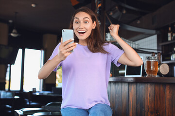 Surprised woman after winning of her sports bet in pub