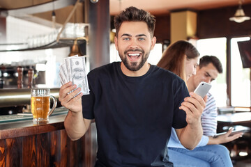 Happy young man after winning of his sports bet in pub