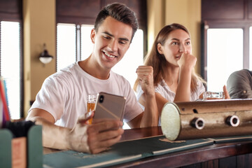 Young people placing sports bet in pub