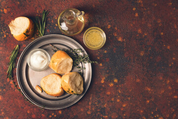Plate with fresh bread and different spices on grunge background